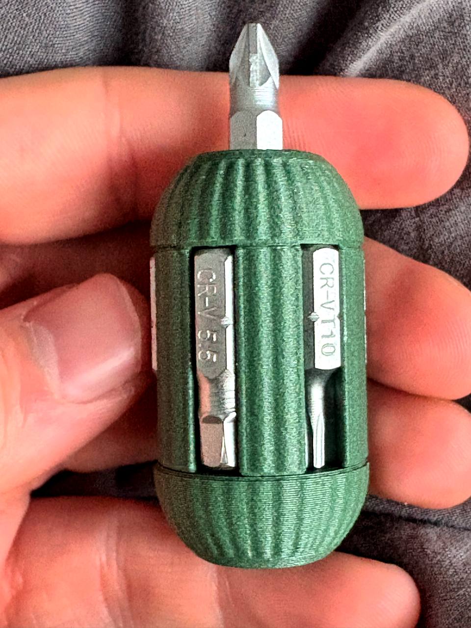 BitKey — compact 3D-printed keychain screwdriver with 6 CR-V bits, held in hand for scale